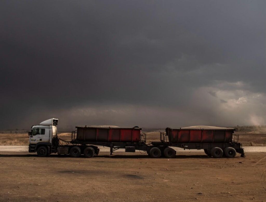 CLC Trucks provides a June 2026 update about the June Fuel update and showing appreciation to Truck Drivers. A commercial transport truck facing severe, dark winter storm clouds on an open South African route, illustrating the daily sacrifices and dangers truck drivers experience.